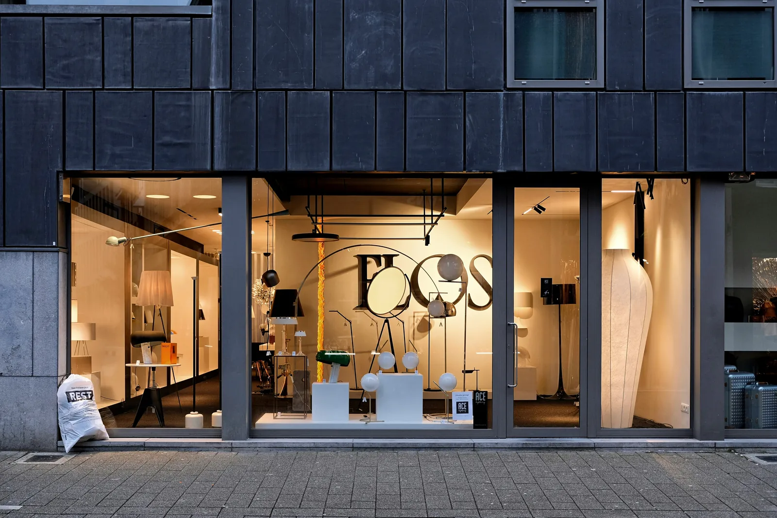 A lit shop window at dusk, display lighting visible from the street